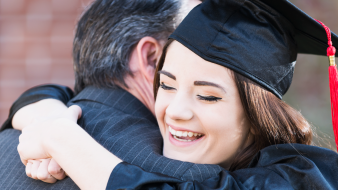 Image of grad hugging a parent