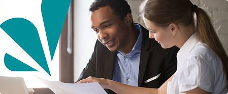 Image of two people looking over documents