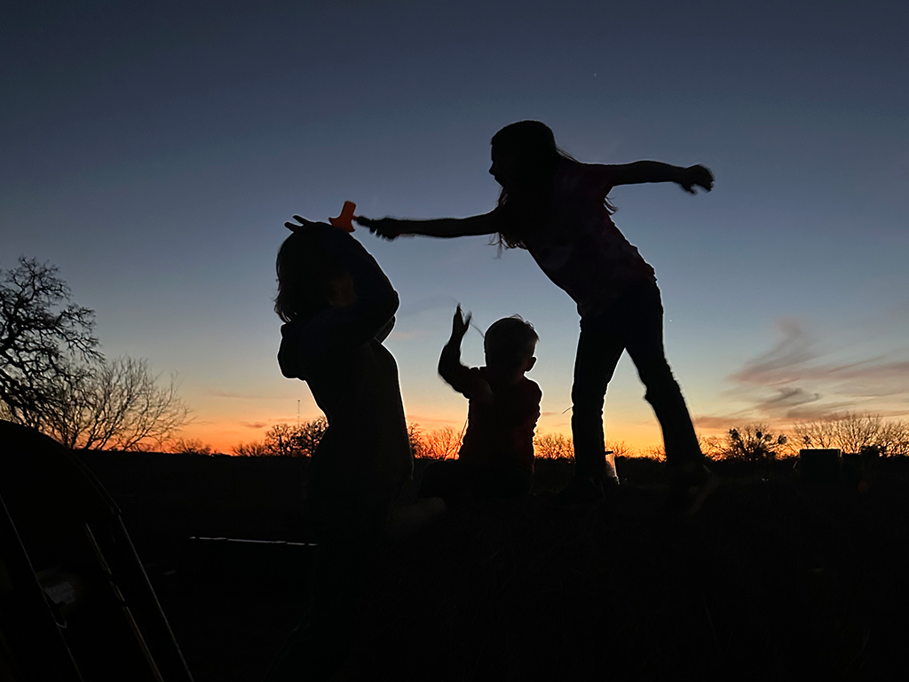 Sunset Silhouettes Playing on Haystacks